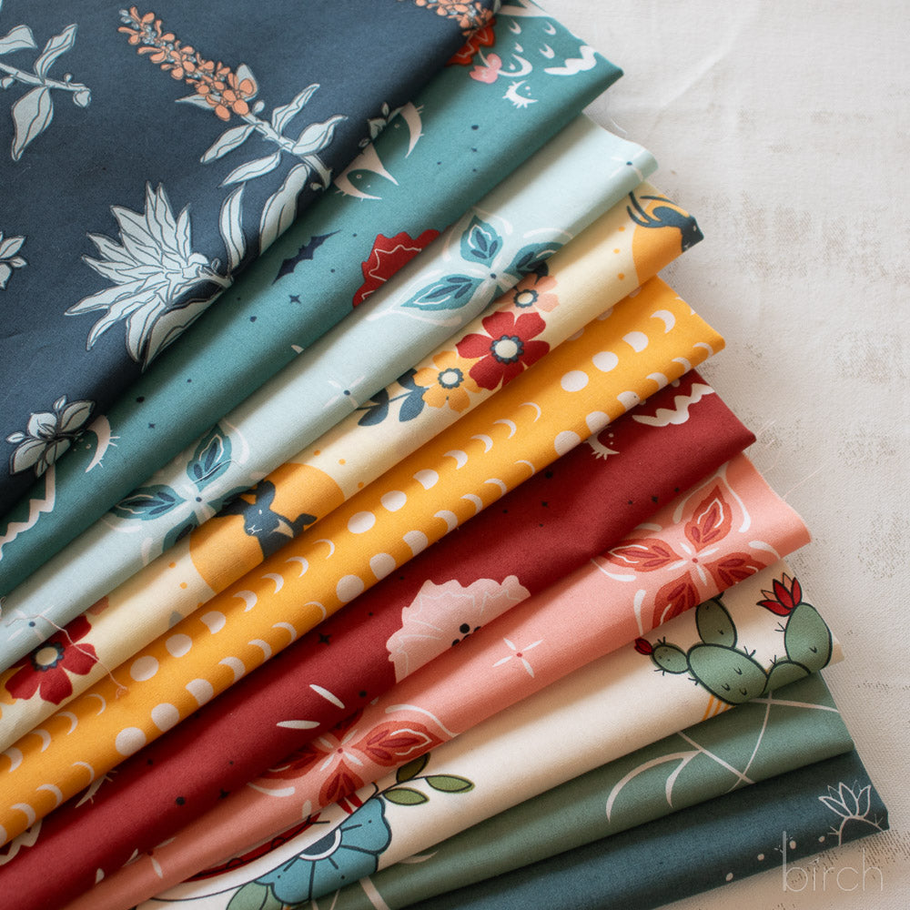 Stack of colorful fabric swatches with various patterns on a light background
