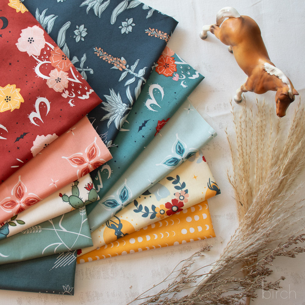 Collection of colorful fabric swatches with floral patterns on a light surface.