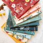 Stack of colorful fabric swatches with various patterns on a light surface.